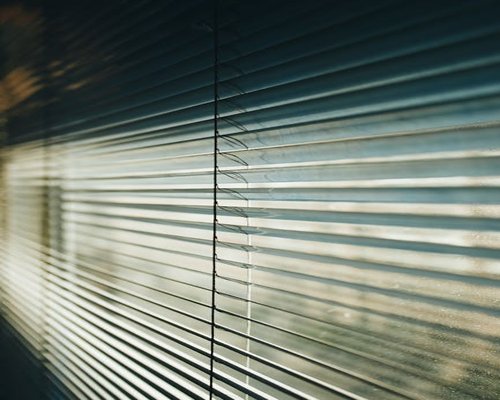 Sunlight entering a modern room through window blinds